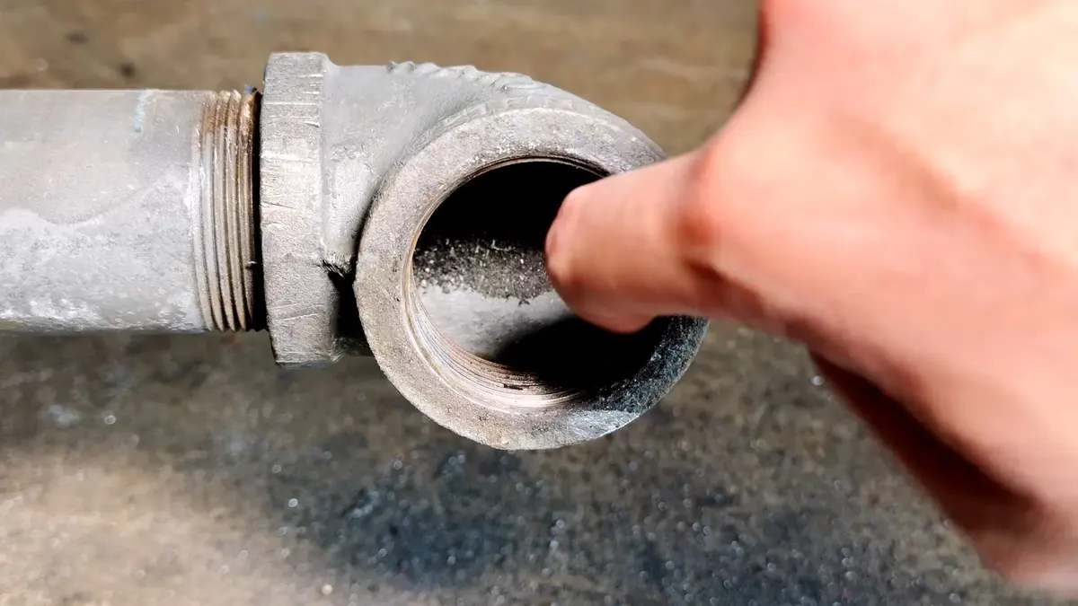 Corroded cast iron drain pipe and replacement connection illustrating Cast Iron vs. PVC Drain Pipe in Lebanon Homes